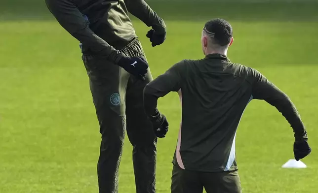 Manchester City's Erling Haaland, left, and Phil Foden attend a training session at the City Football Academy, Manchester, England, Tuesday, Feb. 18, 2025, ahead of the Champions League playoff second leg soccer match between Real Madrid and Manchester City. (Martin Rickett/PA via AP)