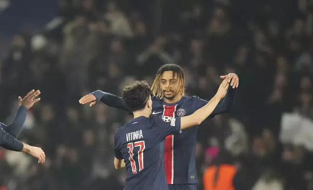 PSG's Vitinha , left, celebrates with teammate PSG's Bradley Barcola after scoring his side's third goal during the Champions League playoff second leg soccer match between Paris Saint-Germain and Brest at the Parc des Princes in Paris, Wednesday, Feb. 19, 2025. (AP Photo/Michel Euler)