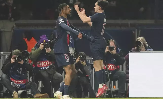 PSG's Bradley Barcola, left, celebrates with a teammate after scoring the opening goal of his team against Brest during the Champions League playoff second leg soccer match between Paris Saint-Germain and Brest at the Parc des Princes in Paris, Wednesday, Feb. 19, 2025. (AP Photo/Michel Euler)