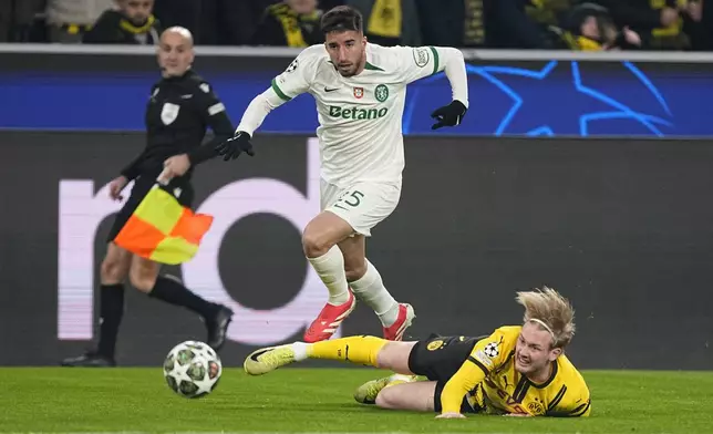 Dortmund's Julian Brandt tackles Sporting's Goncalo Inacio during the Champions League playoff second leg soccer match between Borussia Dortmund and Sporting CP at the Signa-Iduna Park in Dortmund, Germany, Wednesday, Feb. 19, 2025. (AP Photo/Martin Meissner)