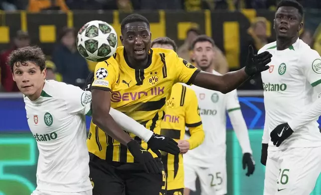 Sporting's Eduardo Quaresma left, and Dortmund's Serhiou Guirassy fight for the ball during the Champions League playoff second leg soccer match between Borussia Dortmund and Sporting CP at the Signa-Iduna Park in Dortmund, Germany, Wednesday, Feb. 19, 2025. (AP Photo/Martin Meissner)