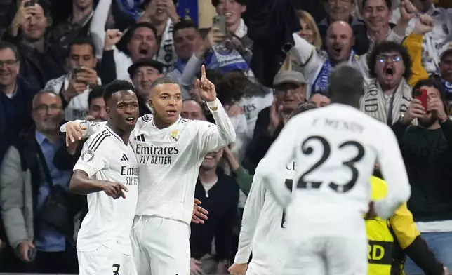 Real Madrid's Kylian Mbappe celebrates with teammates after scoring his sides first goal during the Champions League playoff second leg soccer match between Real Madrid and Manchester City at the Santiago Bernabeu Stadium in Madrid, Spain, Wednesday, Feb. 19, 2025. (AP Photo/Manu Fernandez)