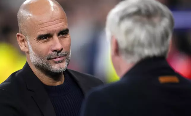 Manchester City's head coach Pep Guardiola, left, greets Real Madrid's head coach Carlo Ancelotti during the Champions League playoff second leg soccer match between Real Madrid and Manchester City at the Santiago Bernabeu Stadium in Madrid, Spain, Wednesday, Feb. 19, 2025. (AP Photo/Manu Fernandez)
