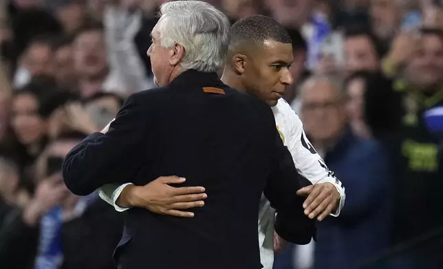 Real Madrid's head coach Carlo Ancelotti hugs Real Madrid's Kylian Mbappe during the Champions League playoff second leg soccer match between Real Madrid and Manchester City at the Santiago Bernabeu Stadium in Madrid, Spain, Wednesday, Feb. 19, 2025. (AP Photo/Manu Fernandez)