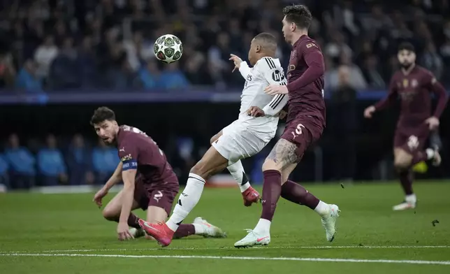 Real Madrid's Kylian Mbappe, center, scores the opening goal of his team during the Champions League playoff second leg soccer match between Real Madrid and Manchester City at the Santiago Bernabeu Stadium in Madrid, Spain, Wednesday, Feb. 19, 2025. (AP Photo/Bernat Armangue)