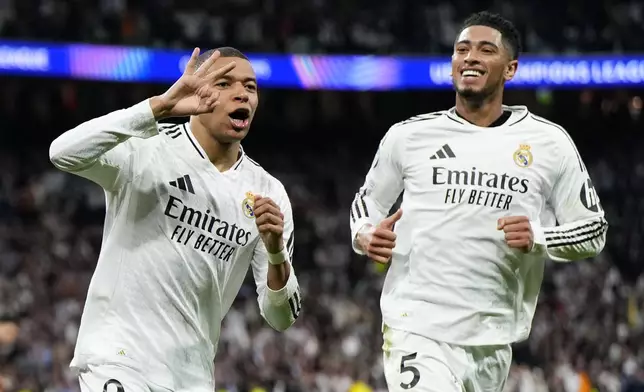 Real Madrid's Kylian Mbappe celebrates with Real Madrid's Jude Bellingham, right, after scoring his sides third goal during the Champions League playoff second leg soccer match between Real Madrid and Manchester City at the Santiago Bernabeu Stadium in Madrid, Spain, Wednesday, Feb. 19, 2025. (AP Photo/Manu Fernandez)