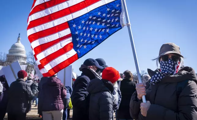 A federal employee who asked not to be named holds an U.S. flag that she flew upside down "as a sign of distress," during the "No Kings Day" protest on Presidents Day in Washington, in support of federal workers and against recent actions by President Donald Trump and Elon Musk, Monday, Feb. 17, 2025, by the Capitol in Washington. The protest was organized by the 50501 Movement, which stands for 50 Protests 50 States 1 Movement. (AP Photo/Jacquelyn Martin)