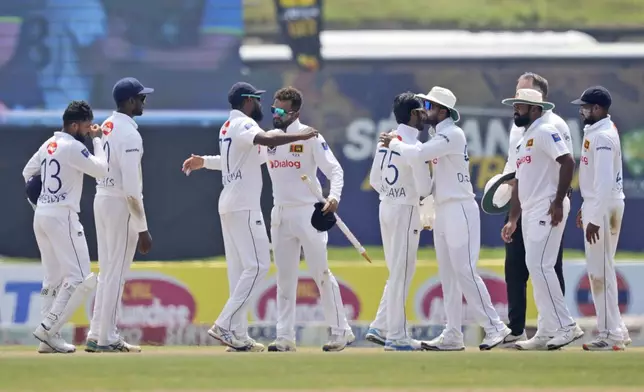 Sri Lankan players congratulate Dimuth Karunaratne who played his career last match at the end of the second test cricket match between Sri Lanka and Australia in Galle, Sri Lanka, Sunday, Feb. 9, 2025. (AP Photo/Eranga Jayawardena)