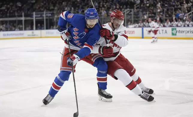 New York Rangers' Urho Vaakanainen, left, and Carolina Hurricanes' Andrei Svechnikov compete for the puck during the third period of an NHL hockey game, Tuesday, Jan. 28, 2025, in New York. (AP Photo/Seth Wenig)