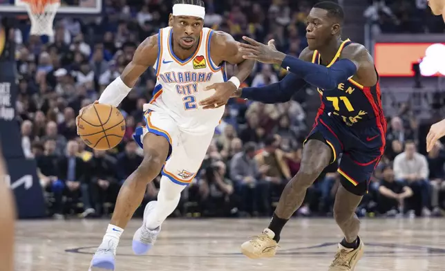 Golden State Warriors guard Dennis Schröder (71) defends against Oklahoma City Thunder guard Shai Gilgeous-Alexander during the first half of an NBA basketball game Wednesday, Jan. 29, 2025, in San Francisco. (AP Photo/Benjamin Fanjoy)