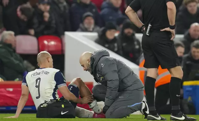 Tottenham's Richarlison gets treatment before leaving the field injured during the English League Cup semifinal second leg soccer match between Liverpool and Tottenham Hotspur at Anfield Stadium in Liverpool, England, Thursday, Feb. 6, 2025. (AP Photo/Jon Super)