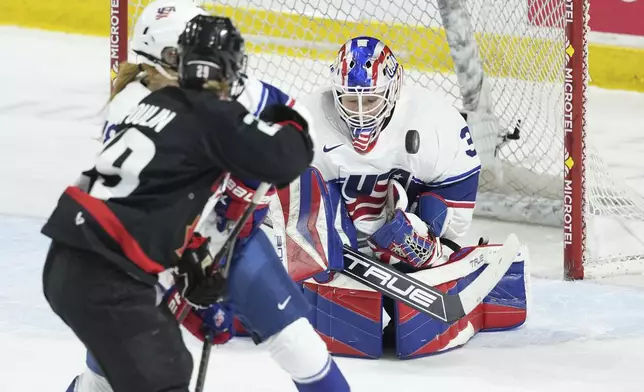 Team USA goaltender Aerin Frankel, right, makes a save as Team Canada's Marie-Philip Poulin looks for a rebound during the first period of a Rivalry Series hockey game in Summerside, Prince Edward Island, Canada, Saturday, Feb. 8, 2025. (Darren Calabrese/The Canadian Press via AP)