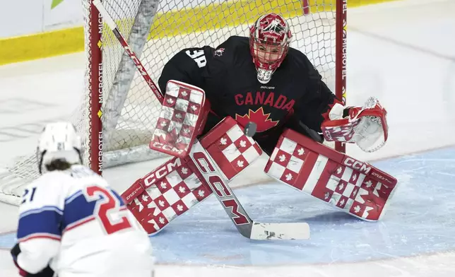 Team Canada goaltender Emerance Maschmeyer, right, makes a save on Team USA's Hilary Knight during the first period of a Rivalry Series hockey game in Summerside, Prince Edward Island, Canada, Saturday, Feb. 8, 2025. (Darren Calabrese/The Canadian Press via AP)