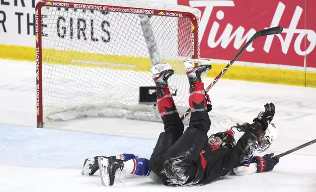 Canada's Laura Stacey, left, celebrates her empty-net goal while falling into Team USA's Kelly Pannek during the third period of Rivalry Series hockey action in Summerside, Prince Edward Island, Canada, Saturday, Feb. 8, 2025. (Darren Calabrese/The Canadian Press via AP)