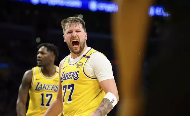 Los Angeles Lakers guard Luka Doncic (77) reacts after making a shot during the second half of an NBA basketball game against the Charlotte Hornets, Wednesday, Feb. 19, 2025, in Los Angeles. (AP Photo/William Liang)