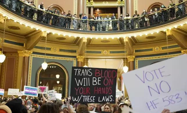 Protesters fill the Iowa state Capitol to denounce a bill that would strip the state civil rights code of protections based on gender identity, Thursday, Feb. 27, 2025, in Des Moines, Iowa. (AP Photo/Charlie Neibergall)