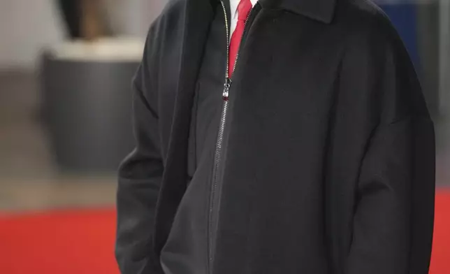 Ferrari driver Lewis Hamilton of Britain poses for cameras as he arrives to the F1@75 launch event at the O2 arena in London, Tuesday, Feb. 18, 2025. (AP Photo/Kin Cheung)