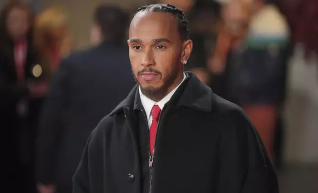 Ferrari driver Lewis Hamilton of Britain poses for cameras as he arrives to the F1@75 launch event at the O2 arena in London, Tuesday, Feb. 18, 2025. (AP Photo/Kin Cheung)