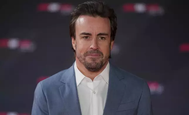 Aston Martin driver Fernando Alonso of Spain poses for cameras as he arrives to the F1 75 Live event at the O2 arena in London, Tuesday, Feb. 18, 2025. (AP Photo/Kin Cheung)