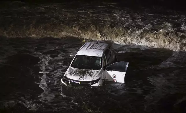 An emergency vehicle is hit by surf after being pushed into the ocean during a storm in the Palisades Fire zone Thursday, Feb. 13, 2025, in Malibu, Calif. (AP Photo/Ethan Swope)