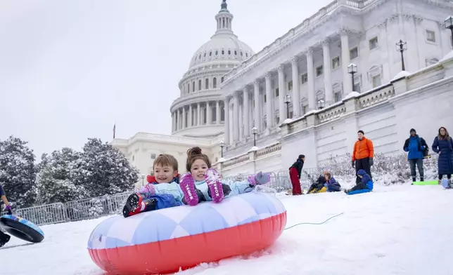 James Prince, 4, and Olivia Averyt, 4, sled down a hill at the Capitol, Wednesday, Feb. 12, 2025, after a snowstorm in Washington. (AP Photo/Jacquelyn Martin)