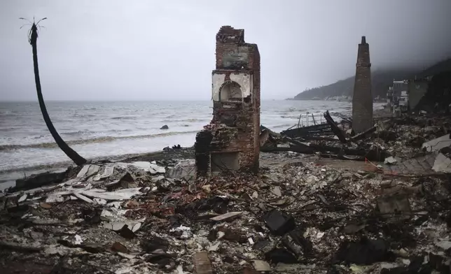 A fire-damaged beachfront property is seen in the Palisades Fire zone during a storm Thursday, Feb. 13, 2025, in Malibu, Calif. (AP Photo/Ethan Swope)