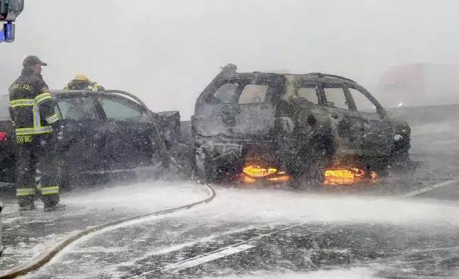 In this image provided by the Multnomah County Sheriff's Office officials respond to a SUV that caught fire on westbound Interstate 84 on Thursday, Feb. 13, 2025, near Multnomah Falls, Ore. (Multnomah County Sheriff's Office via AP)
