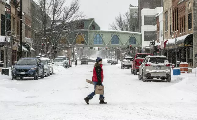 Pedestrians make their way across Dubuque Street in Iowa City, Iowa, Wednesday, Feb. 12, 2025. (Nick Rohlman/The Gazette via AP)