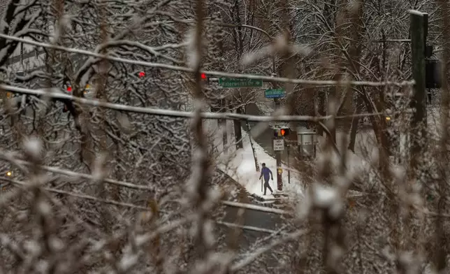 A person walks along Kelly Drive and Water Works Drive after an overnight snow fall in Philadelphia, Wednesday, Feb. 12, 2025. (Alejandro A. Alvarez/The Philadelphia Inquirer via AP)