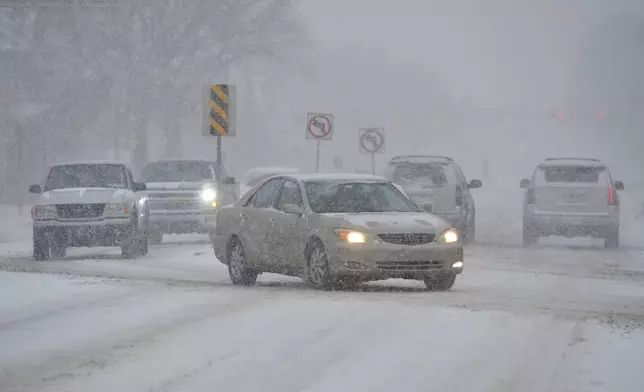 Heavy snow falls as drivers turn onto Niles Avenue Wednesday, Feb. 12, 2025, in St. Joseph, Mich., while inter weather advisories remain in effect as a winter storm moves across Michigan. (Don Campbell/The Herald-Palladium via AP)