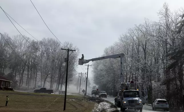 Utility crews work on power lines after a winter storm blanketed the area Thursday, Feb. 13, 2025, in Franklin County, Va. (Heather Rousseau/The Roanoke Times via AP)