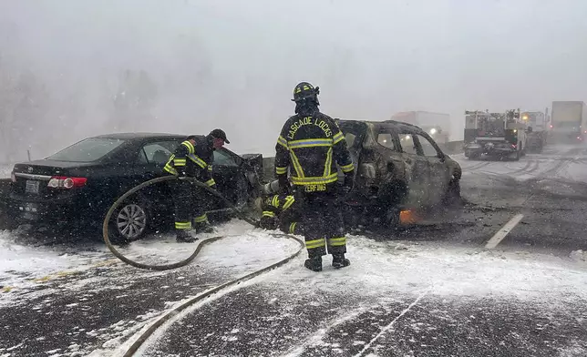 In this image provided by the Multnomah County Sheriff's Office officials respond after a vehicle caught fire on westbound Interstate 84 on Thursday, Feb. 13, 2025, near Multnomah Falls, Ore. (Multnomah County Sheriff's Office via AP)