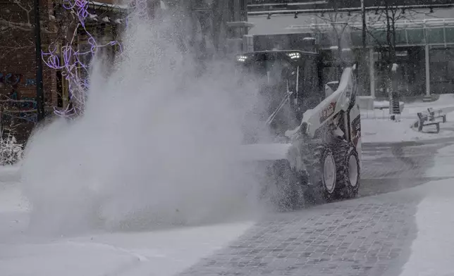 City workers clear snow from the pedestrian mall in Iowa City, Iowa on Wednesday, Feb. 12, 2025. (Nick Rohlman/The Gazette)