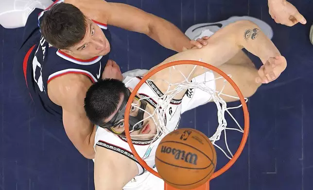 Los Angeles Clippers guard Bogdan Bogdanovic, left, and Memphis Grizzlies center Zach Edey wait for a rebound during the first half of an NBA basketball game Wednesday, Feb. 12, 2025, in Inglewood, Calif. (AP Photo/Mark J. Terrill)