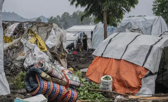 A woman and her child displaced by the fighting between M23 rebels and government soldiers prepare to leave the camp following an instruction by M23 rebels in Goma, Democratic Republic of the Congo, Tuesday, Feb. 11, 2025. (AP Photo/Moses Sawasawa)