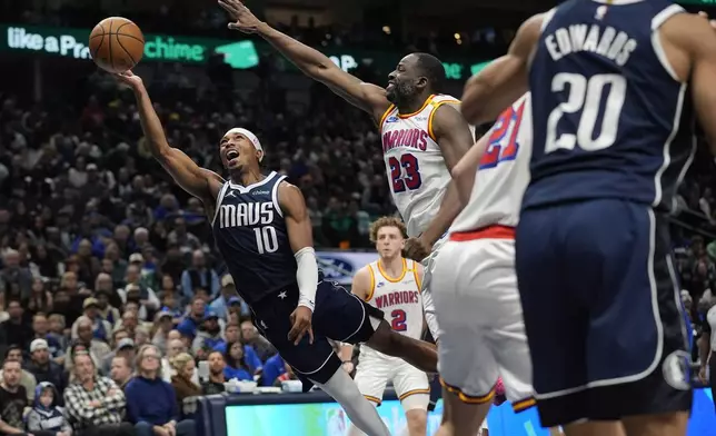 Dallas Mavericks guard Brandon Williams (10) shoots against Golden State Warriors forward Draymond Green (23) during the second half of an NBA basketball game in Dallas, Wednesday, Feb. 12, 2025. (AP Photo/LM Otero)