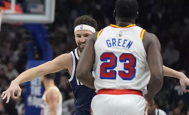 Dallas Mavericks guard Klay Thompson, left, gestures after scoring a 3-pointer against Golden State Warriors forward Draymond Green (23) during the first half of an NBA basketball game in Dallas, Wednesday, Feb. 12, 2025. (AP Photo/LM Otero)