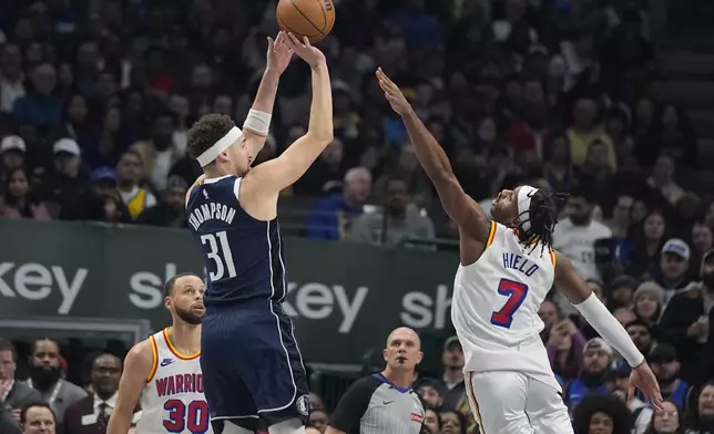 Dallas Mavericks guard Klay Thompson (31) shoots against Golden State Warriors defender Buddy Hield (7), as Stephen Curry (30) looks on, during the first half of an NBA basketball game in Dallas, Wednesday, Feb. 12, 2025. (AP Photo/LM Otero)