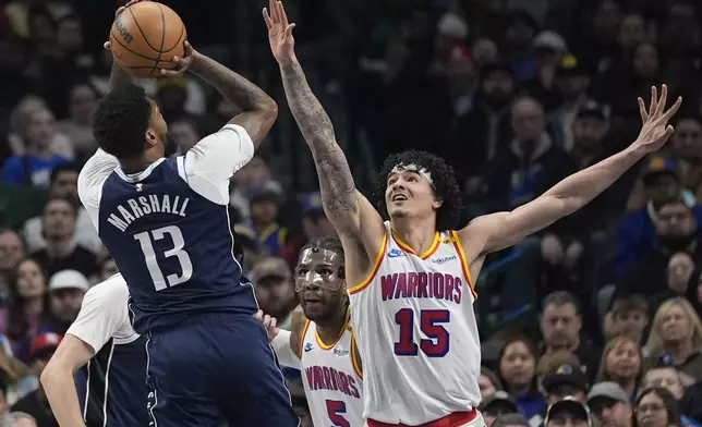 Golden State Warriors forward Gui Santos (15) defends the shot by Dallas Mavericks forward Naji Marshall (13) during the first half of an NBA basketball game in Dallas, Wednesday, Feb. 12, 2025. (AP Photo/LM Otero)