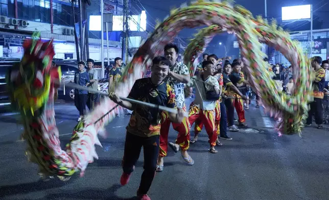 Dragon dancers perform in a torch parade parade ahead of the holy fasting month of Ramadan, in Tangerang, Indonesia, Thursday, Feb. 27, 2025. (AP Photo/Tatan Syuflana)