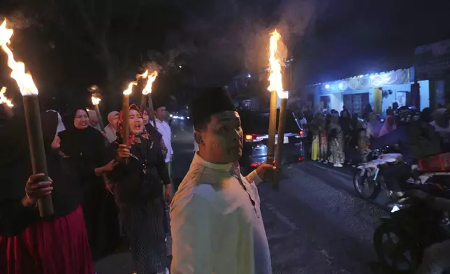Samsul Anwar participates in a torch parade ahead of the holy fasting month of Ramadan, in Tangerang, Indonesia, Thursday, Feb. 27, 2025. (AP Photo/Tatan Syuflana)