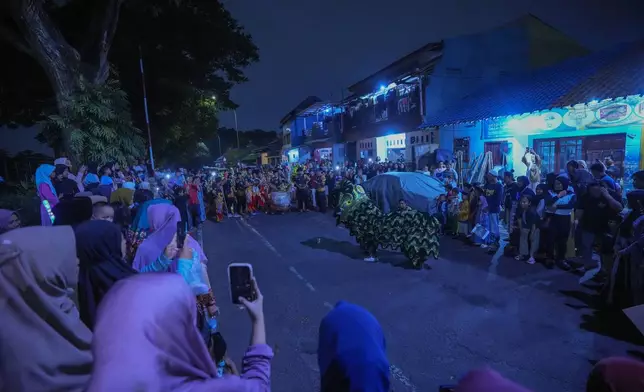 Lion dancers perform in a torch parade ahead of the holy fasting month of Ramadan, in Tangerang, Indonesia, Thursday, Feb. 27, 2025. (AP Photo/Tatan Syuflana)