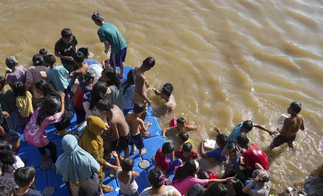 Muslims bathe in the Cisadane River, ahead the holy fasting month of Ramadan in Tangerang, Indonesia, Friday, Feb 28, 2025. (AP Photo/Tatan Syuflana)