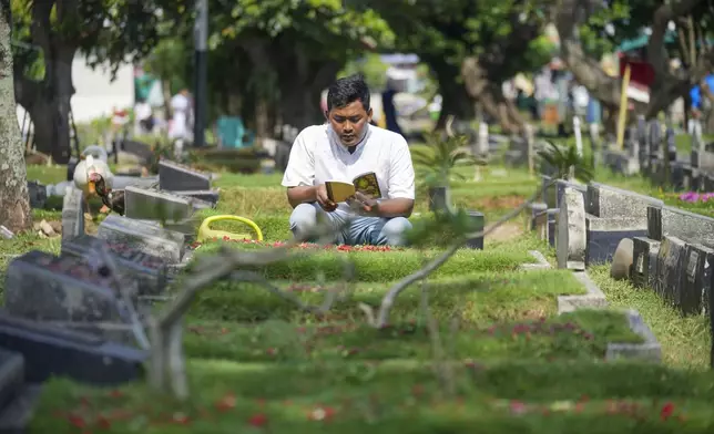 Samsul Anwar prays at his mother's grave at a cemetery prior of the holy fasting month of Ramadan, in Tangerang, Indonesia, Friday, Feb. 28, 2025. (AP Photo/Tatan Syuflana)