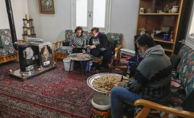 Syrian Christians roast and peel chestnuts at the Church of Saints Sergius and Bacchus after Sunday Mass in the town of Maaloula, Syria, Sunday, Jan. 12, 2025. (AP Photo/Omar Sanadiki)