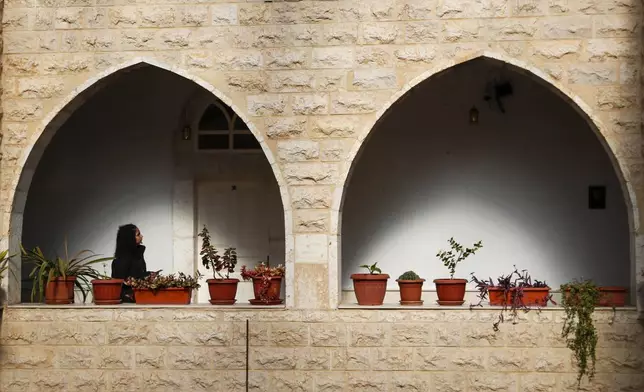 A woman walks by the Church of Saints Sergius and Bacchus after Sunday Mass in the town of Maaloula, Syria, Sunday, Jan. 12, 2025. (AP Photo/Omar Sanadiki)
