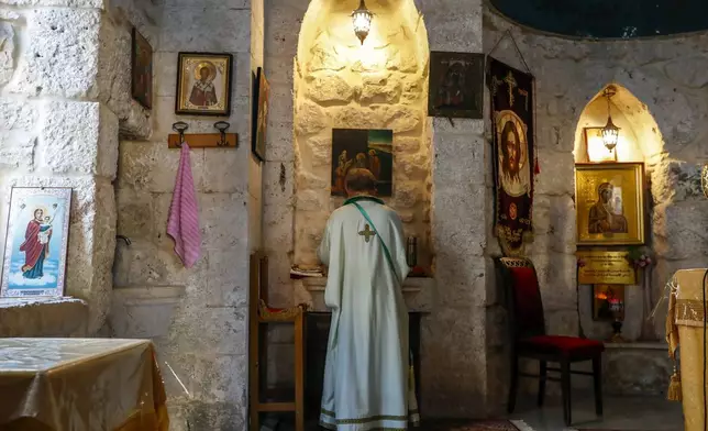 A priest holds Sunday Mass at the Greek Orthodox Convent of Saint Thecla in the town of Maaloula, Syria, Sunday Jan. 12, 2025. (AP Photo/Omar Sanadiki)