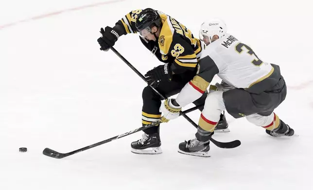 Boston Bruins left wing Brad Marchand (63) and Vegas Golden Knights defenseman Brayden McNabb (3) battle for the puck during the second period of an NHL hockey game, Saturday, Feb. 8, 2025, in Boston. (AP Photo/Mark Stockwell)