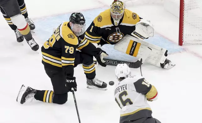 Boston Bruins defenseman Michael Callahan (79) and goaltender Jeremy Swayman (1) defend the net against a shot by Vegas Golden Knights left wing Pavel Dorofeyev (16) during the second period of an NHL hockey game, Saturday, Feb. 8, 2025, in Boston. (AP Photo/Mark Stockwell)