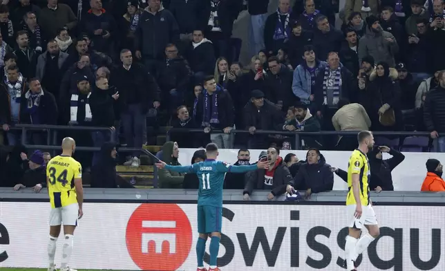Anderlecht's Thorgan Hazard, center, gestures toward the stands as play is disrupted during the Europa League playoff second leg soccer match between Anderlecht and Fenerbahce at the RSC Anderlecht stadium in Brussels, Thursday, Feb. 20, 2025. (AP Photo/Omar Havana)